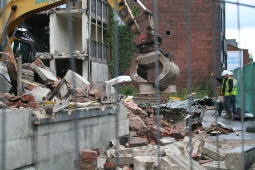 Using an I-beam like a squeegee to level the ground.