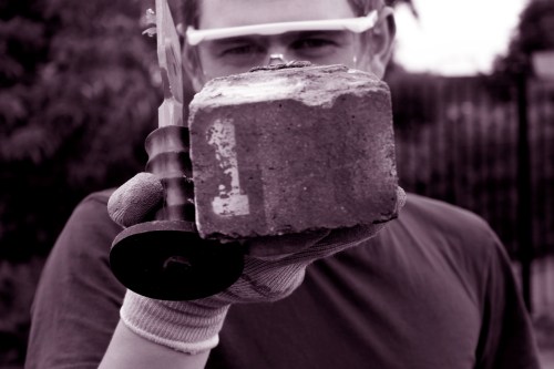 Jamie Robinson (KHOM) with brick number 1, 18 Aug 2014. Photo: Pam Van-Damned Visuals.